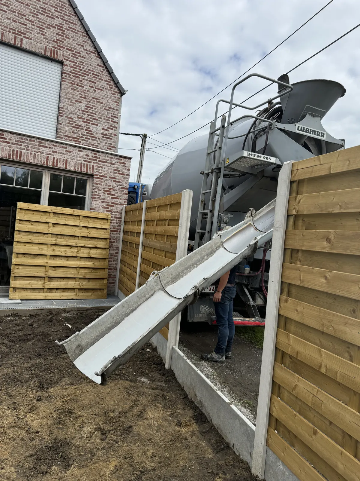 Beton storten met de betonmixer voor een terras in de tuin