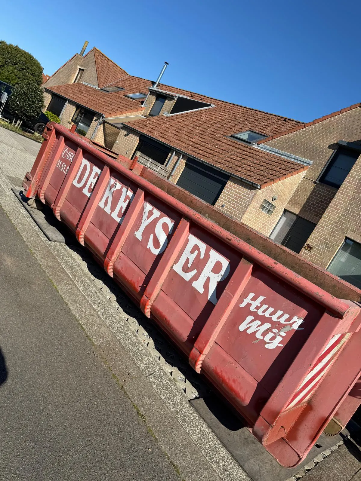 Container waarmee het groenafval van een tuinrenovatie wordt afgevoerd