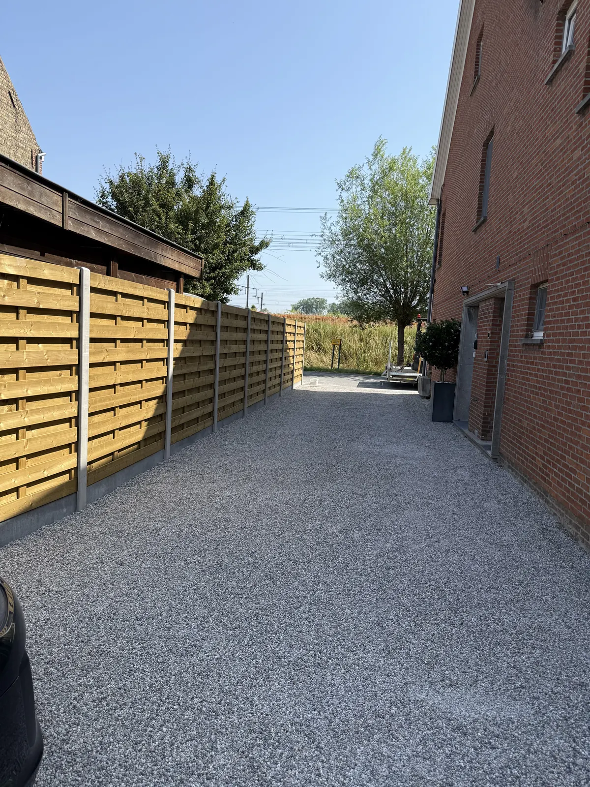 Grindpad met keien aangelegd langs een houten omheining