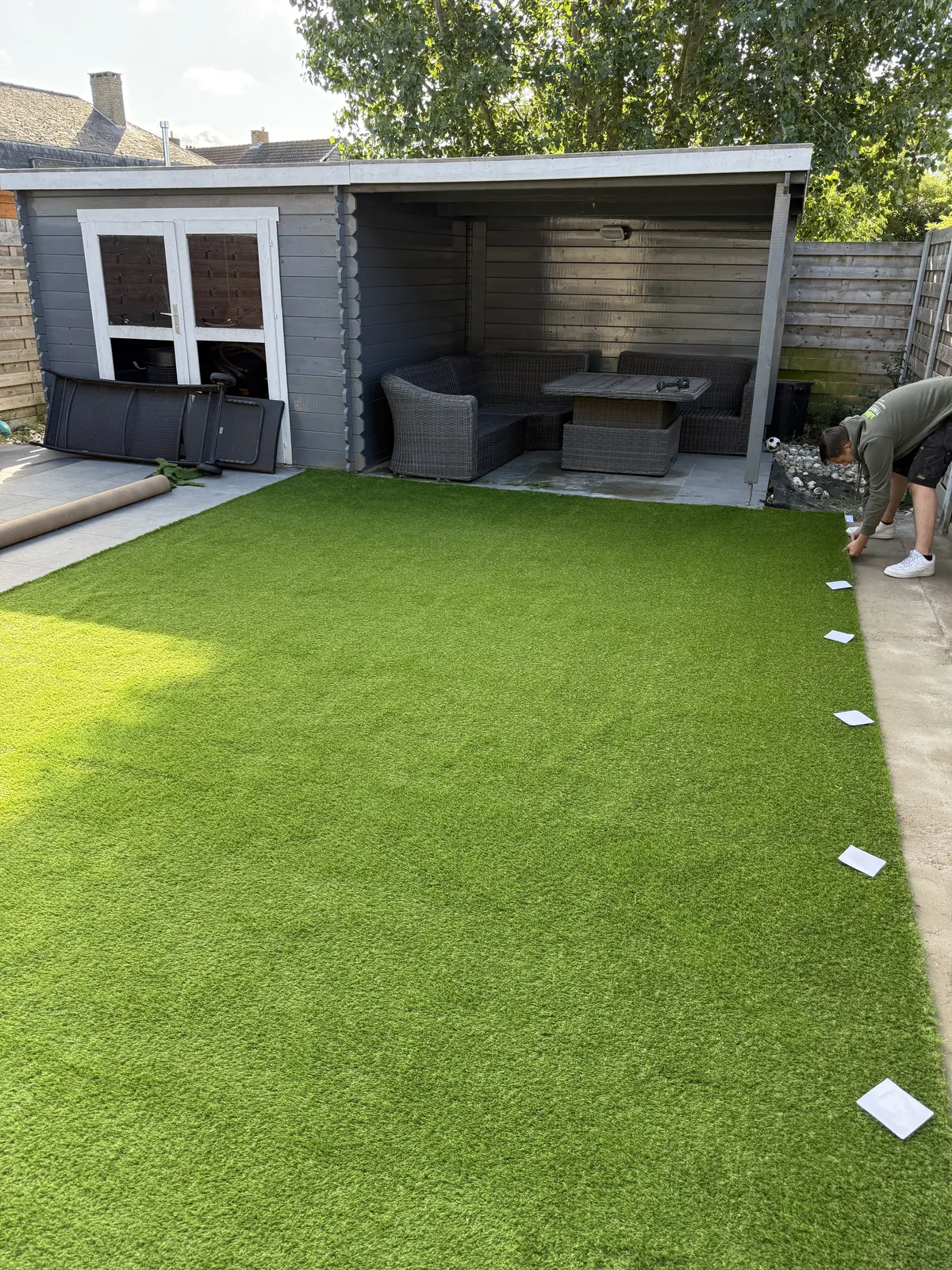 Kunstgras aangelegd in een tuin met overdekt tuinhuis