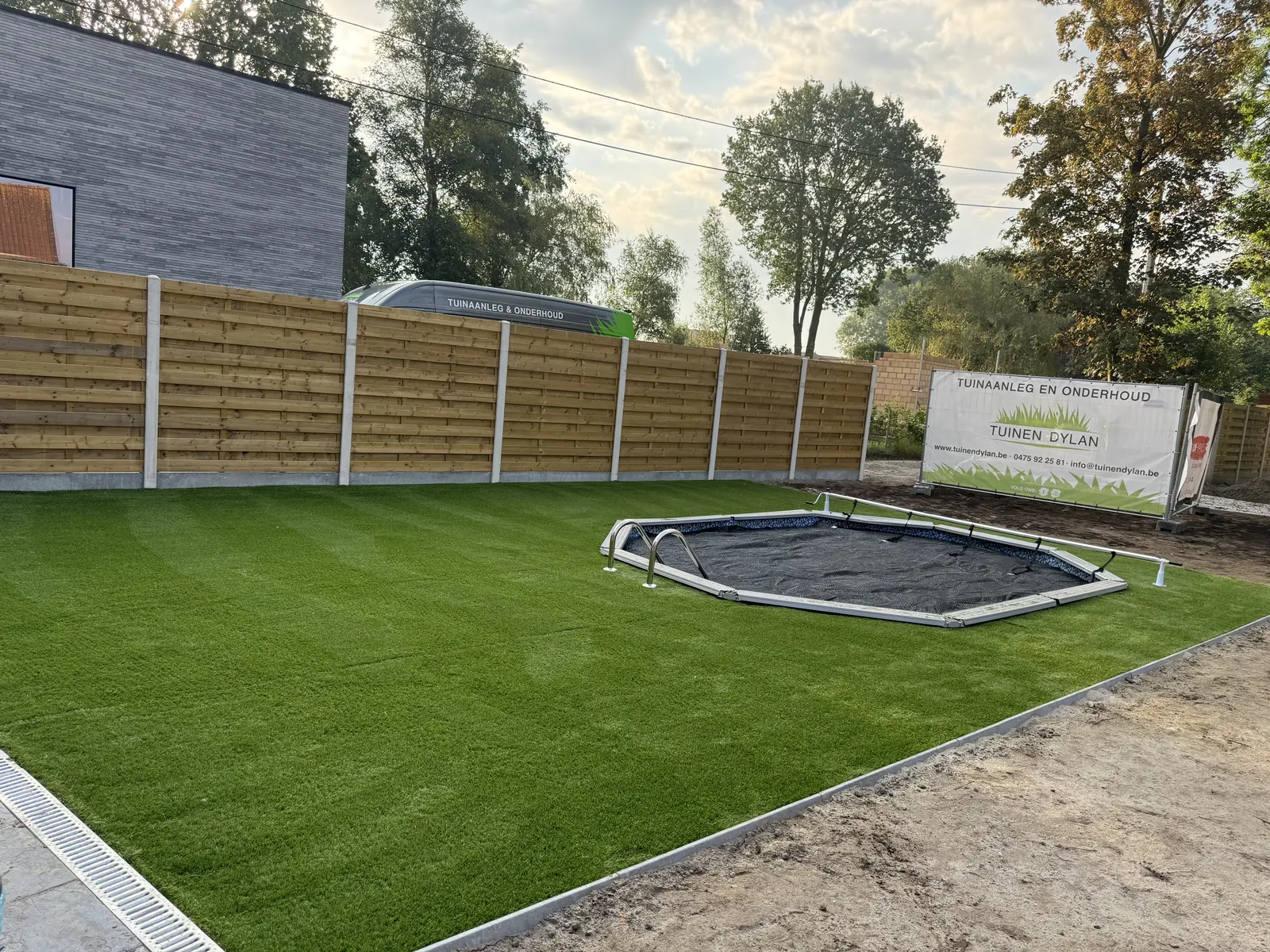 Kunstgras met een ingegraven trampoline in een kindvriendelijke tuin