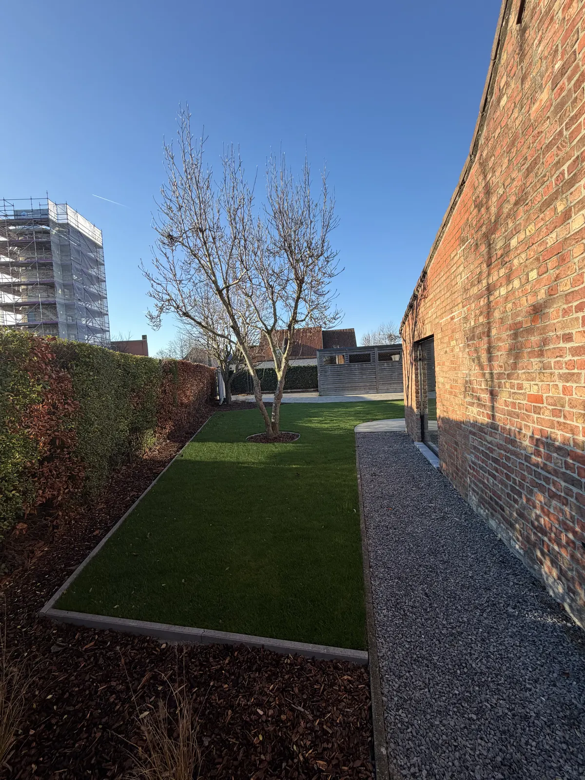 Kunstgras aangelegd in een smalle tuin langs de woning