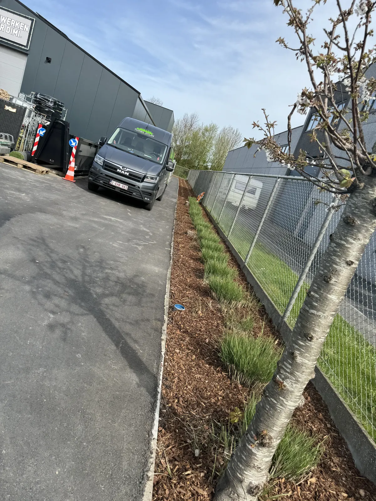 Siergrassen aangeplant langs de omheining van een bedrijfsgebouw