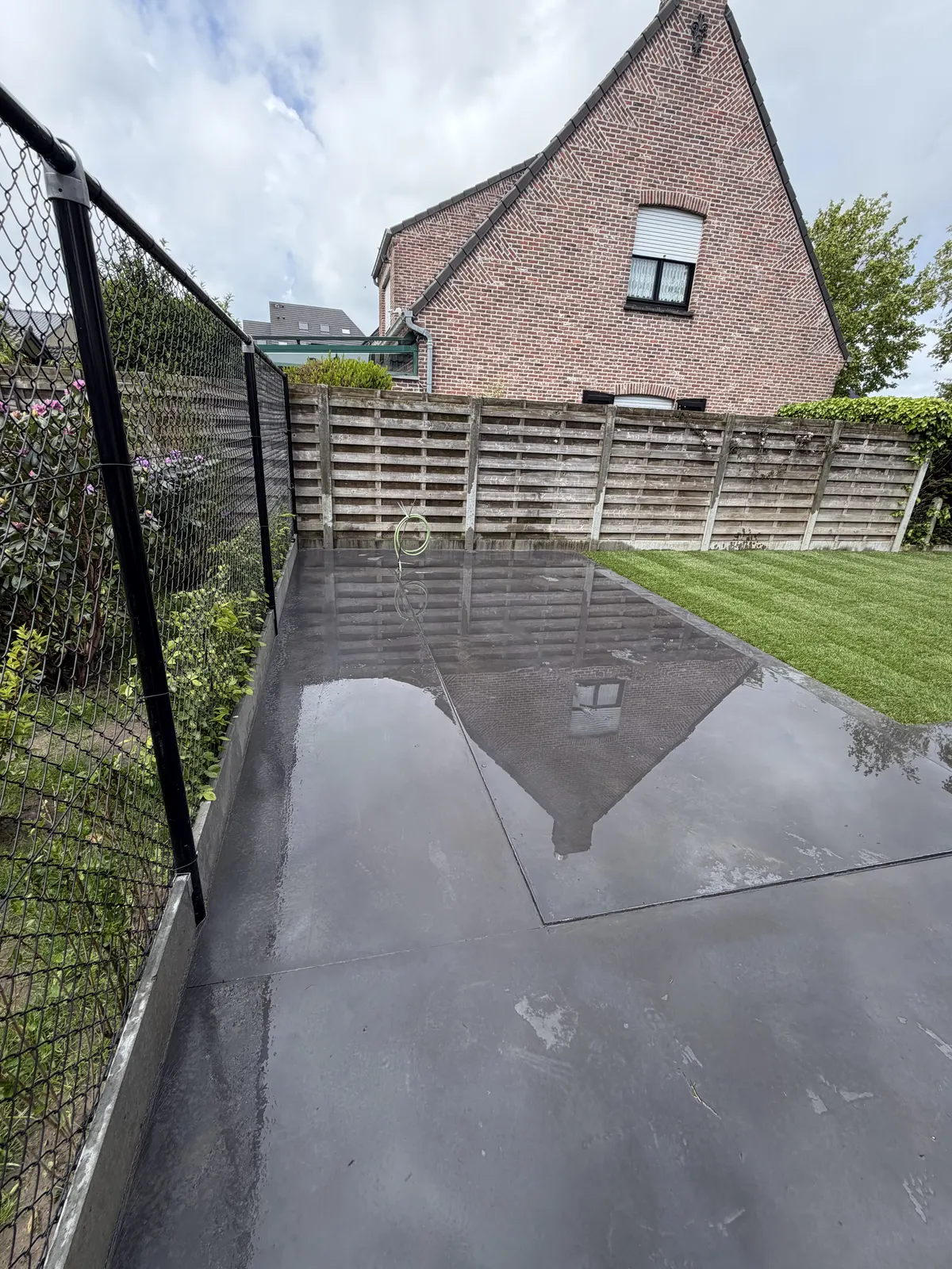 Afgewerkt terras in grote tegels naast een gemaaid gazon