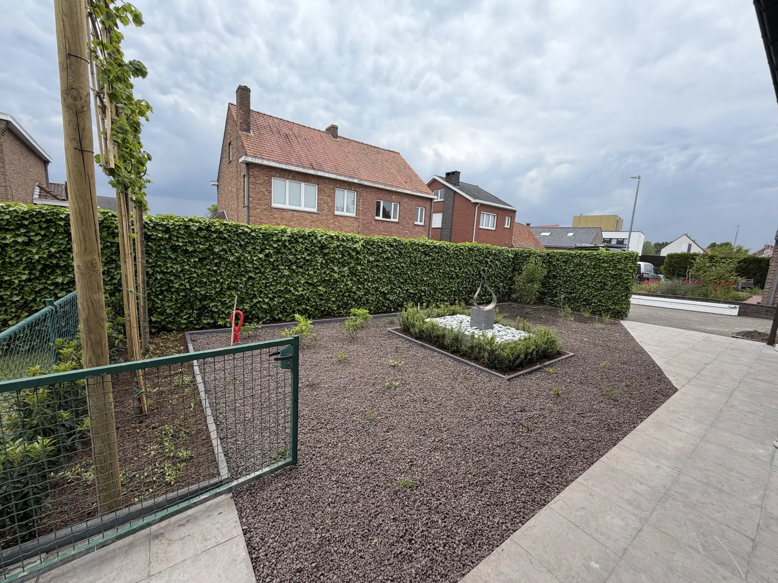 Tuin afgewerkt met lavasteen, haag en nieuwe beplanting