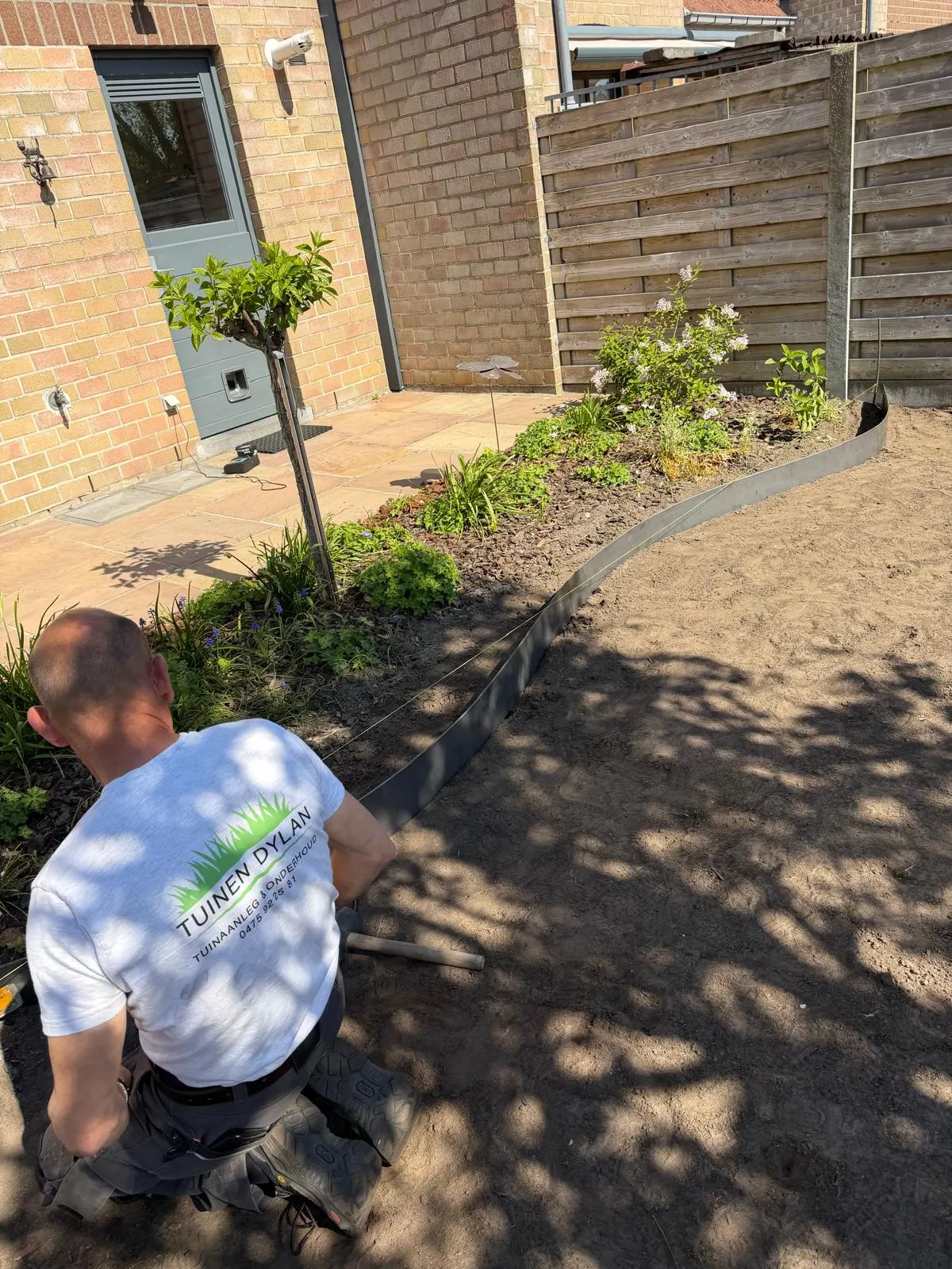 Tuinman van Tuinen Dylan die de beplanting aanlegt in een border
